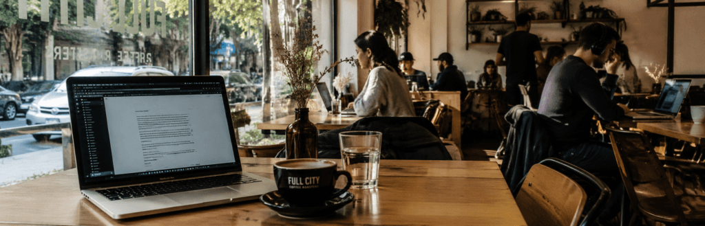 Nómadas digitales trabajando desde una cafetería en Buenos Aires con notebooks y café de especialidad